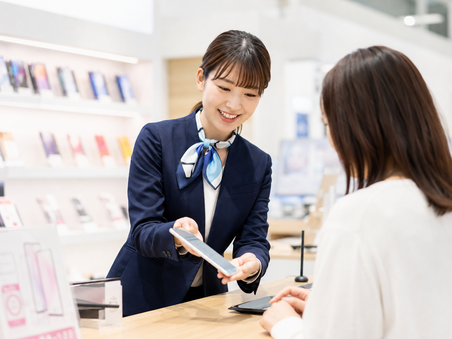 タブレットで案内する女性スタッフ